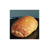 Butery, flaky chocolate croissant on a black plate with a gray background